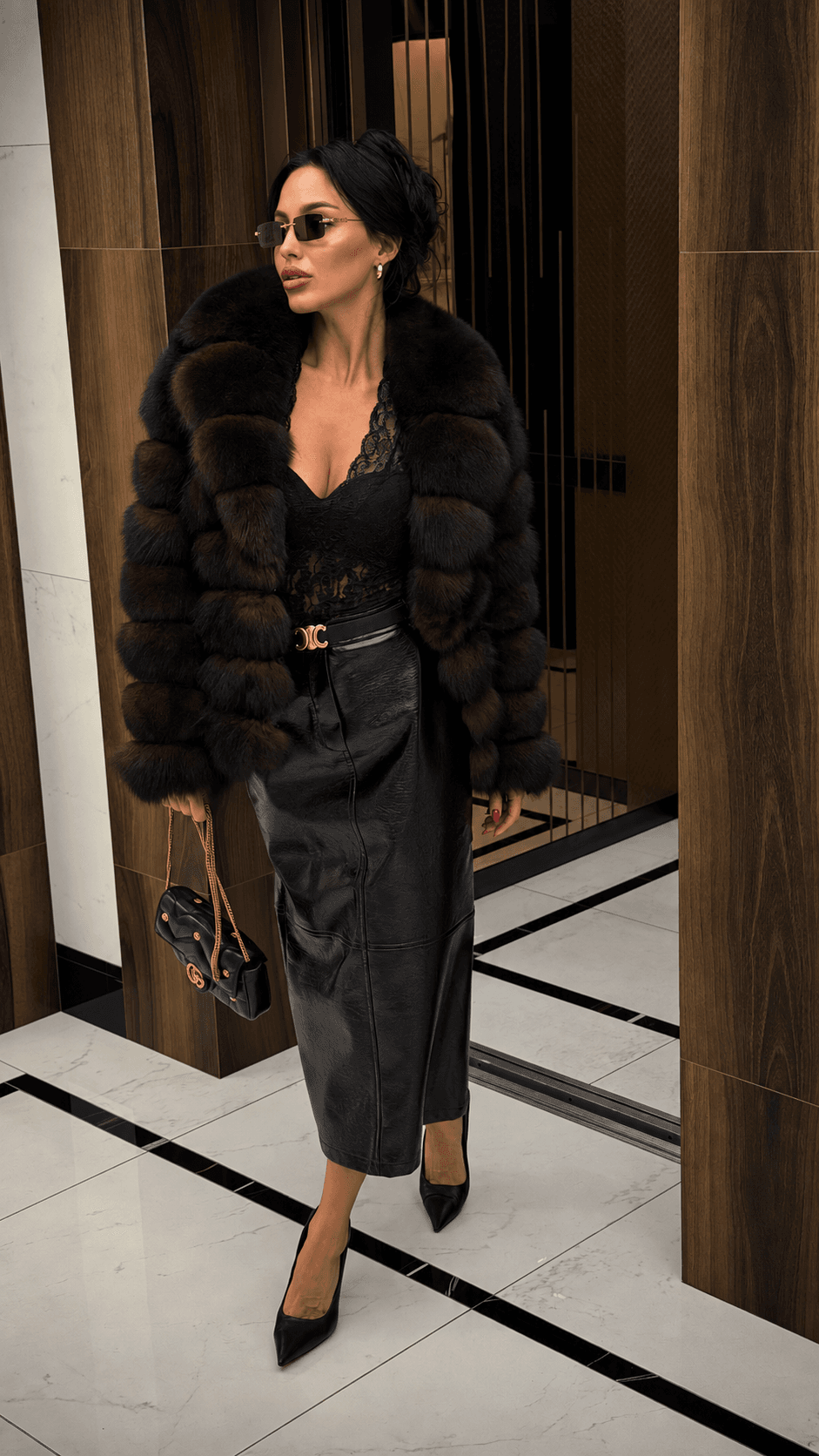 Модель Mono Look в тёмной меховой шубе, кружевном топе и кожаной юбке с чёрной сумкой